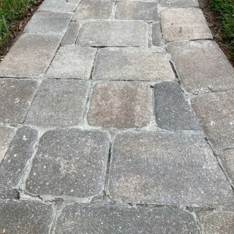Walkway pavers with failed, deteriorating sealer and eroded joint sand before stripping and resealing