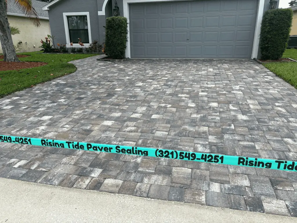 Gray and white rustic paver driveway freshly sealed by Rising Tide Paver Sealing